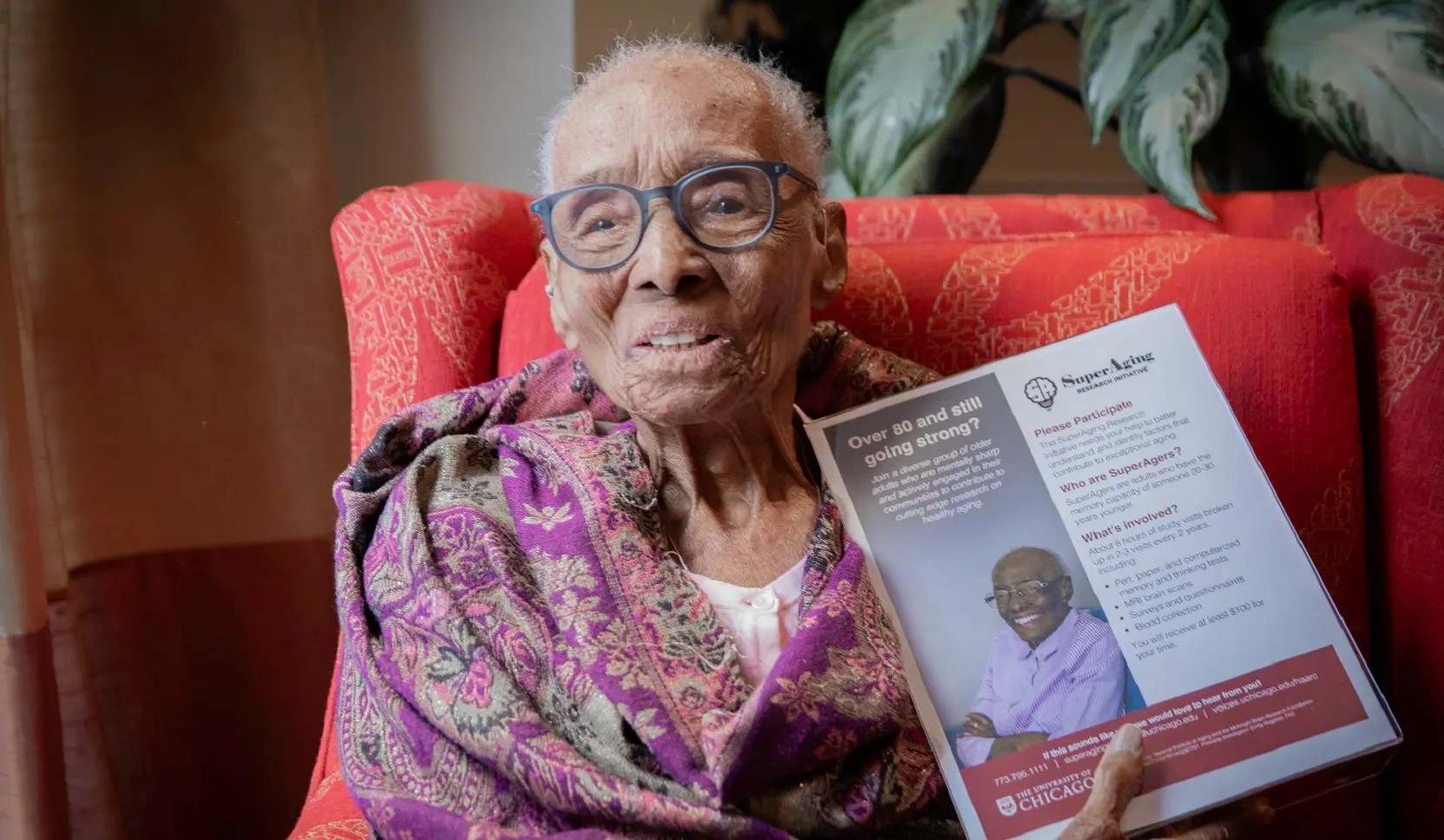 SuperAger Edith Renfrow Smith, 110, holds a flyer for the SuperAging Research Initiative that features a photo of her. Photo by Chris Jones