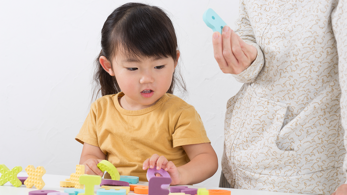 Kid playing with rubber letters