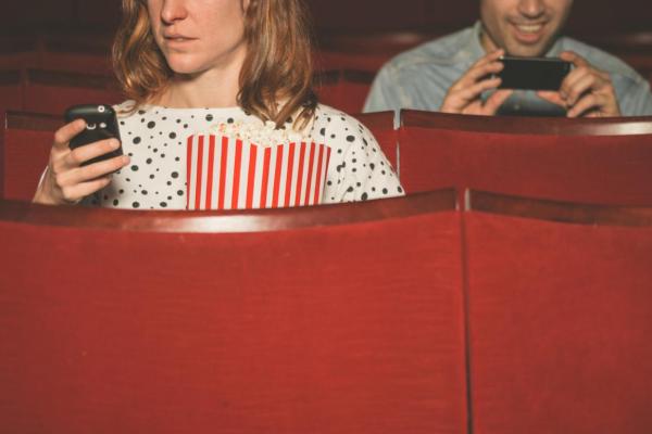 People on their phones in a movie theater