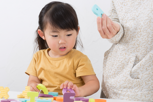 Kid playing with rubber letters